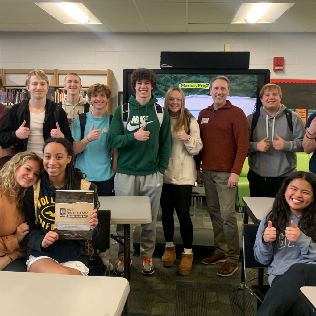 High school students standing at the front of the class to pose for a picture after completing a test prep boot camp event