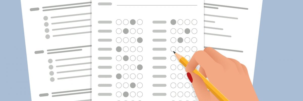 The student filling out answers to exam test answer sheet with a pencil. School and Education. Test score sheet with answers.